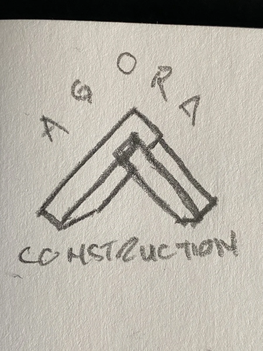 A rough hand-drawn sketch showing an early draft of the A-frame logo — AGORA arched above an A-frame peak built from two interlocking beams meeting at an apex, with CONSTRUCTION straight across the base