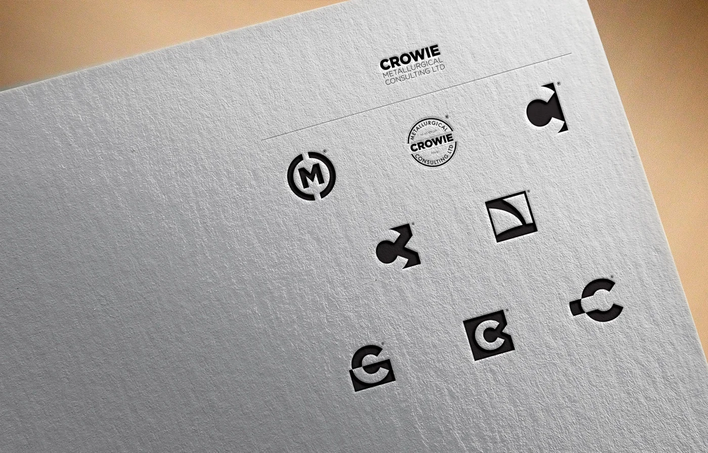 A letterpress mockup showing eight different mark variations debossed into the surface of cream-coloured paper: the chosen EXTRACT mark alongside experimental versions including monogram CMC variants, dimensional 3D constructions, a pour-shape mark, and additional C explorations