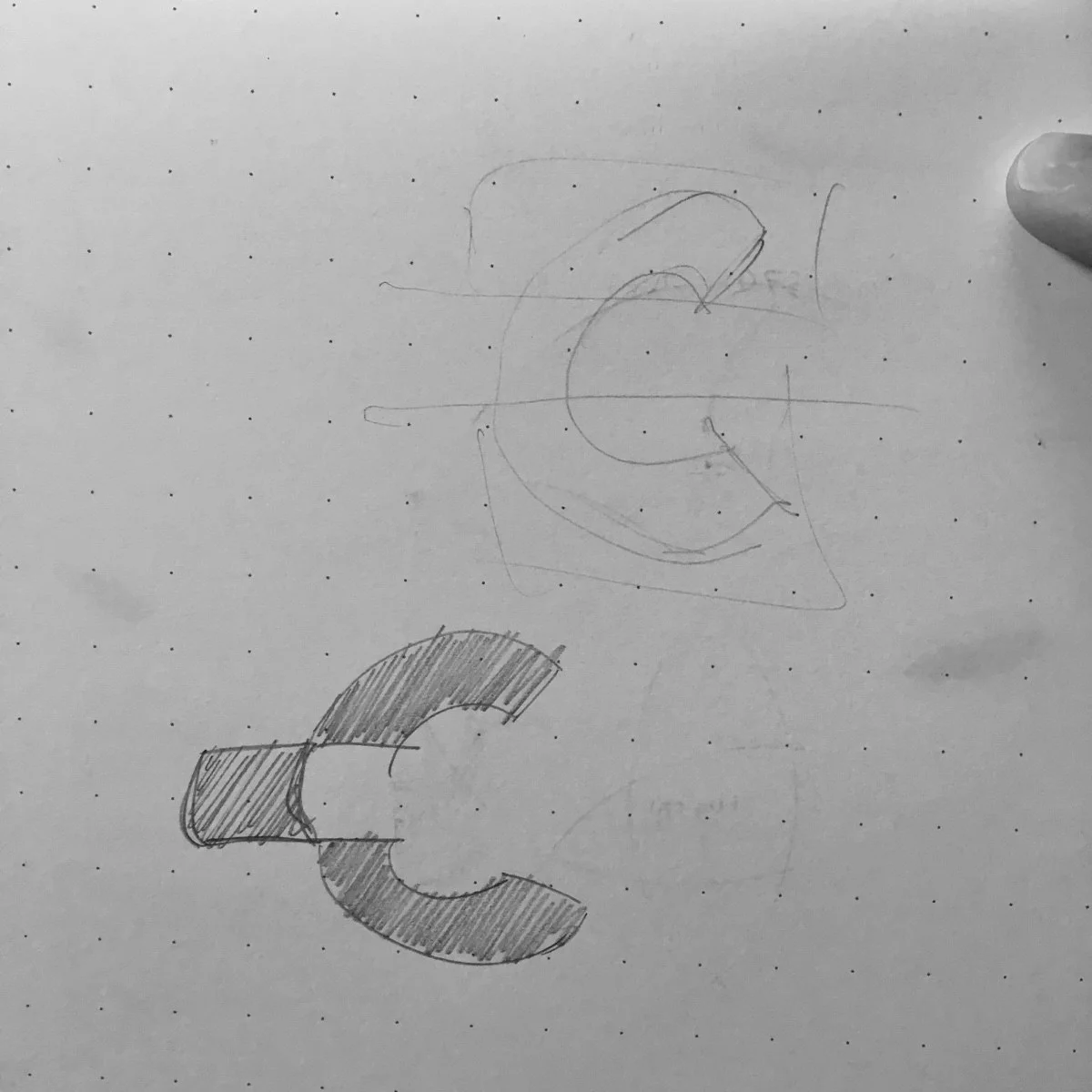 A pencil sketch showing the genesis of the EXTRACT mark: a shaded gold-foil arc lifted clear of a brown rectangular block, with construction lines showing the geometric grid the mark sits on