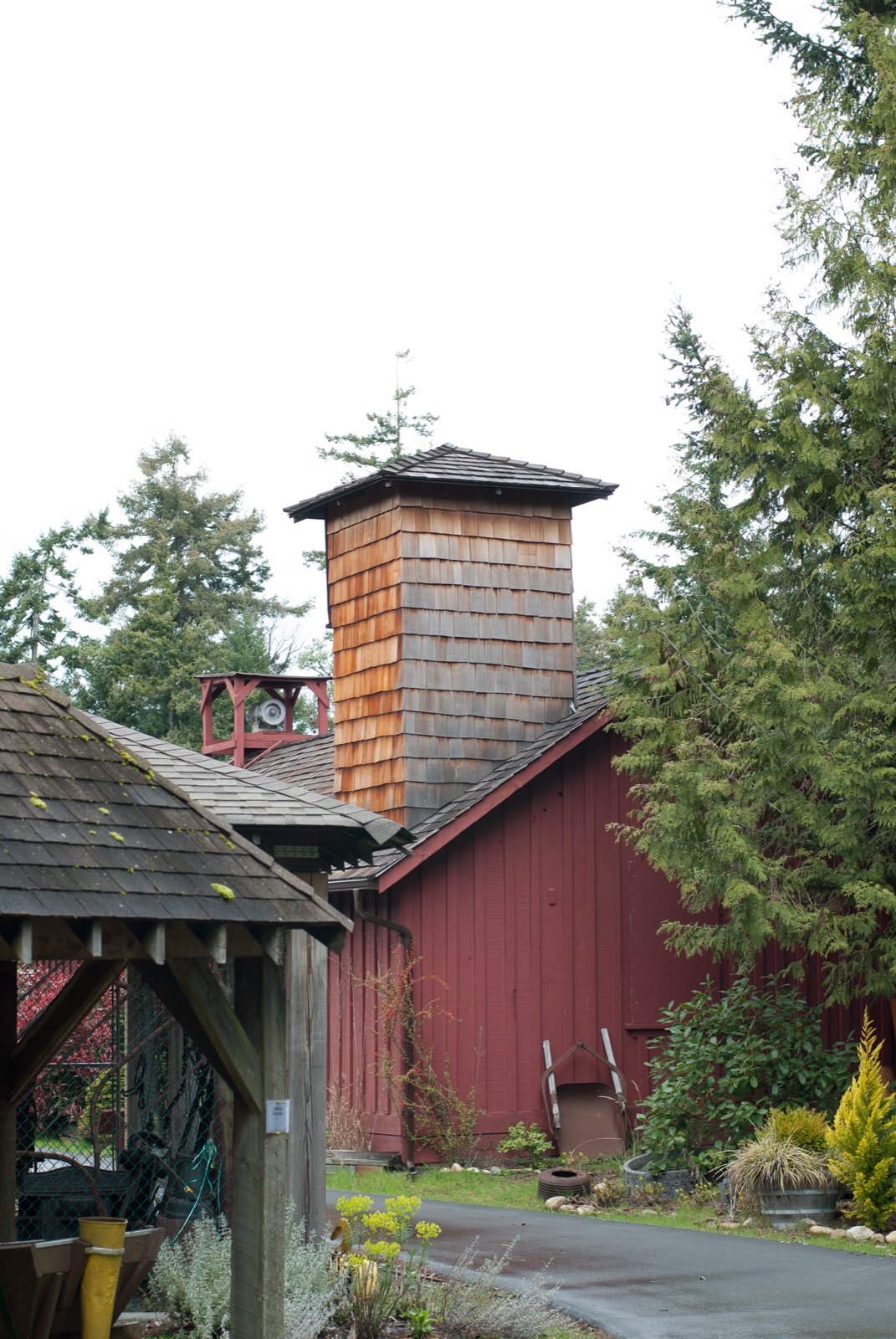 The cedar-shingled water tower and red barn heritage buildings at the Parksville Museum