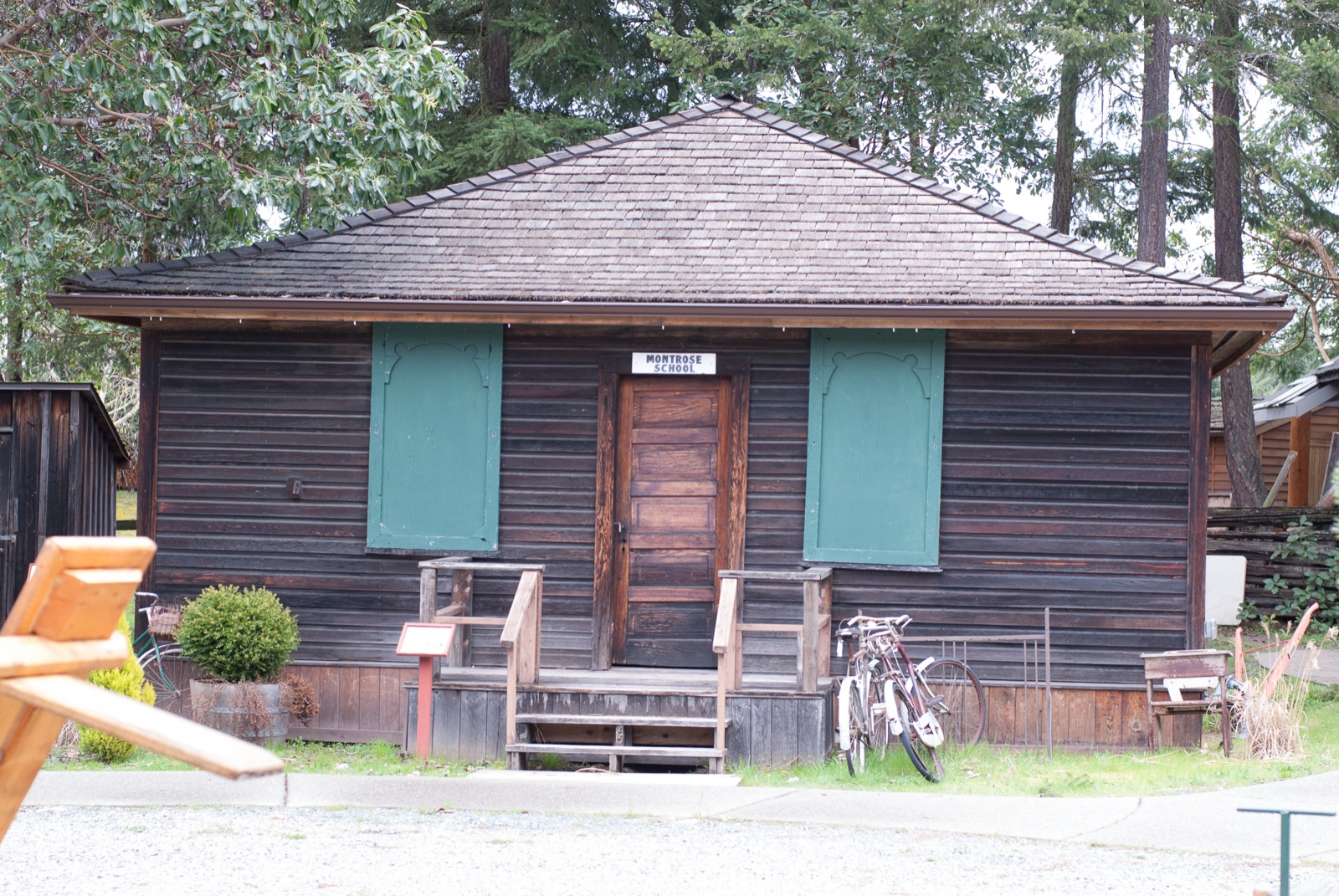 The Mortrose Schoolhouse, a dark wooden heritage building with green shutters