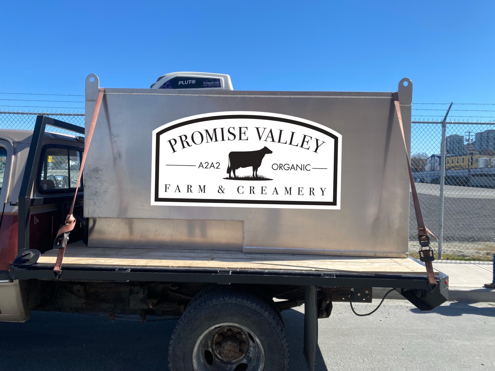 The side of the Promise Valley Farm delivery truck showing the logo applied to the stainless steel milk hauler panel